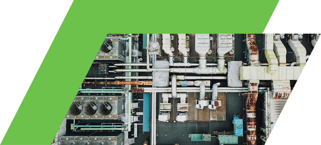 Aerial view of an industrial facility featuring extensive piping and cooling systems.